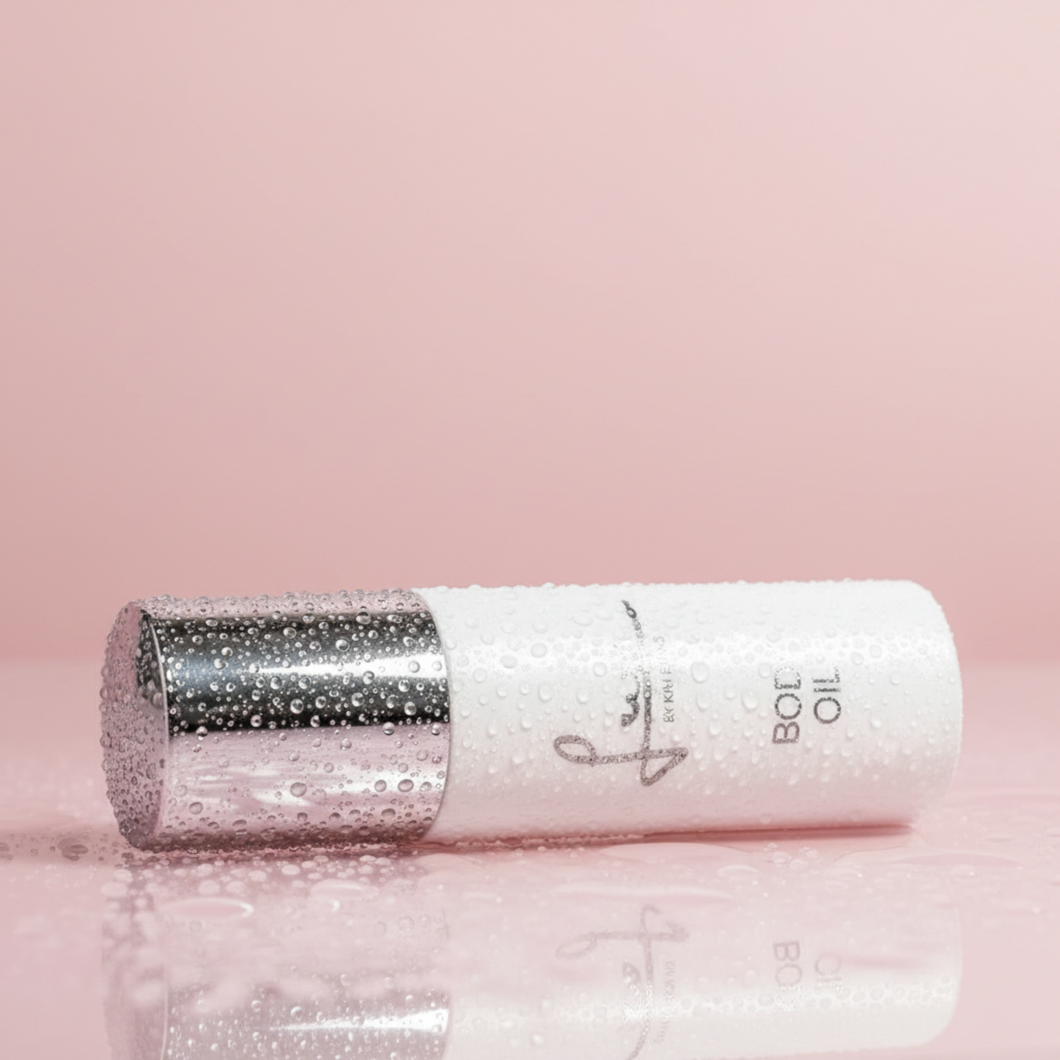 Luxurious body oil bottle with a sleek design, featuring a silver cap and droplets of water, set against a soft pink background. Ideal for achieving radiant skin, this is the best body oil for hydration and nourishment.
